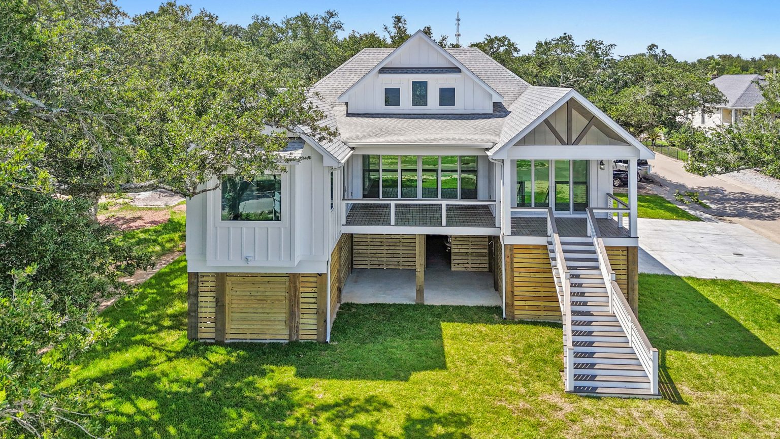 Aerial front elevation of a waterfront raised home built by Full Armour Homes on the Mississippi Gulf Coast